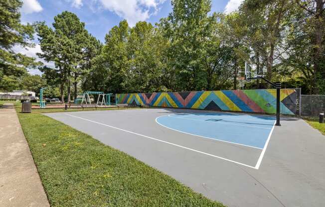 a basketball court with a colorful mural in the background