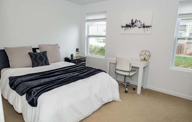 A bedroom with a large bed and a desk.