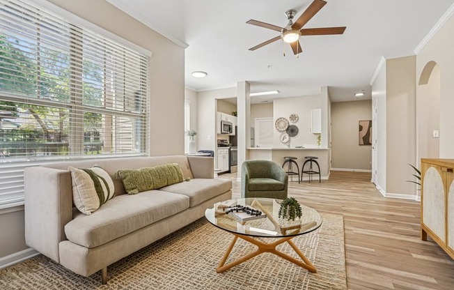 A living room with a beige couch, a green chair, and a coffee table.