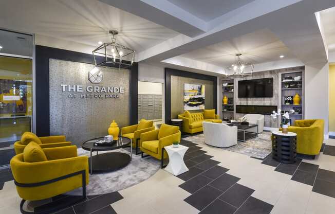 a lobby with yellow couches and chairs and a sign that reads the grange