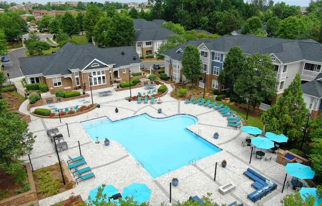 A large swimming pool surrounded by a grassy area and trees.