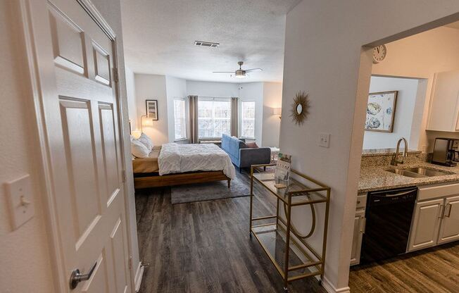 a bedroom with a bed sitting next to a kitchen