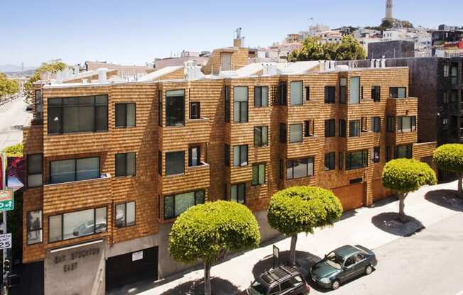 a view from above of a brick apartment building with cars parked in front of it