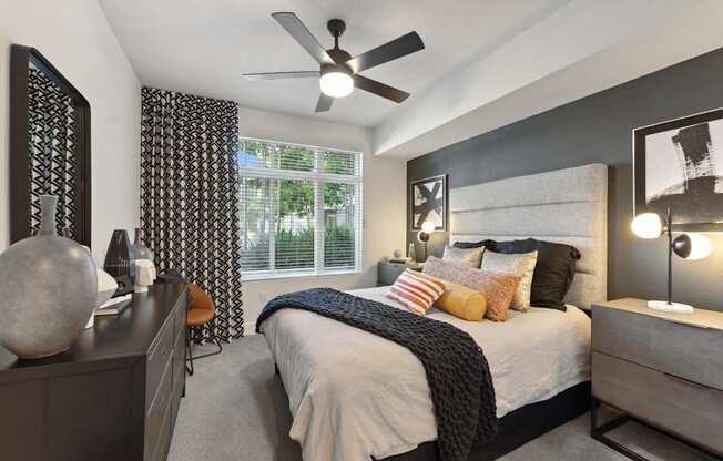 A bedroom with a bed, nightstand, and a ceiling fan.