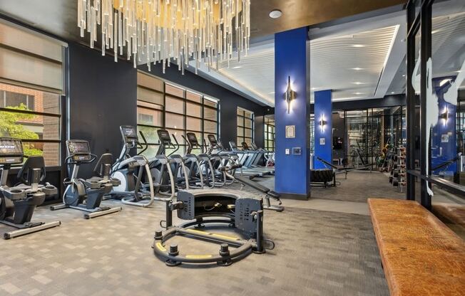 a gym with cardio machines and a chandelier