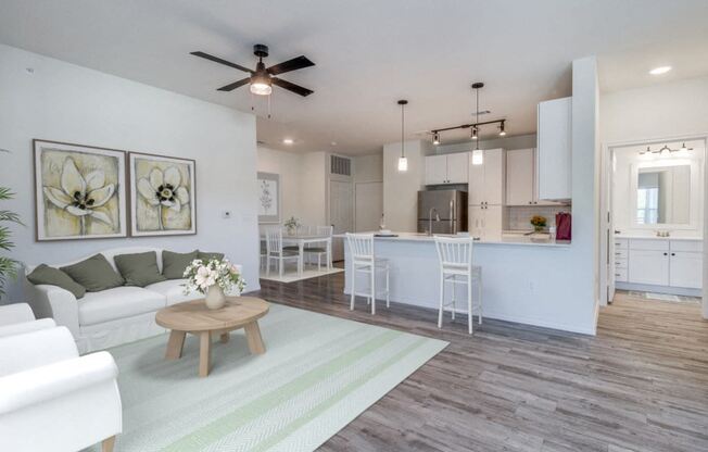 an open living room and kitchen with a ceiling fan