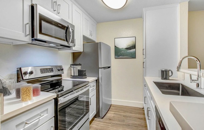 a kitchen with stainless steel appliances and white cabinets