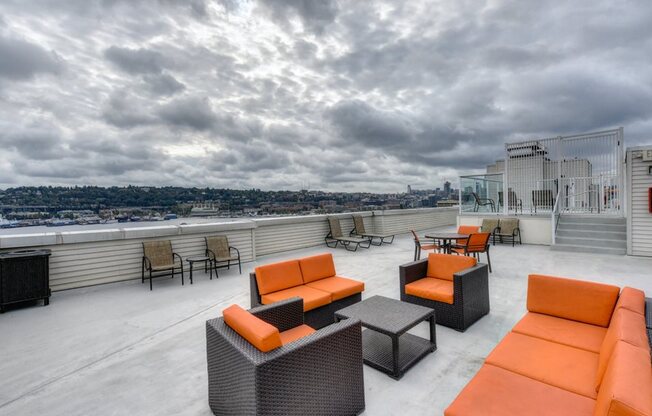 Rooftop Seating Area with Orange Chairs, Sofas and View of City