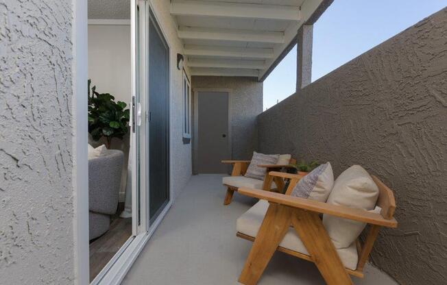 a porch with a wooden table and chairs on it