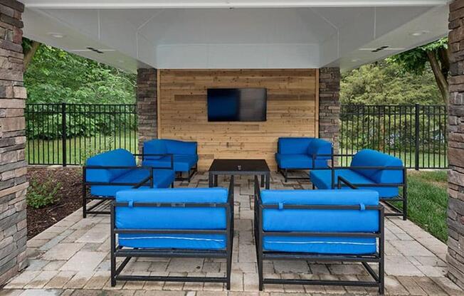 a patio with blue chairs and a table at Trails at Short Pump Apartments, Virginia