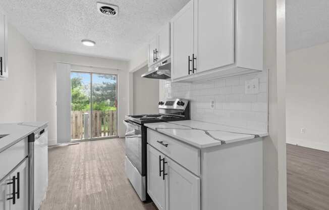 a white kitchen with white cabinets and white appliances