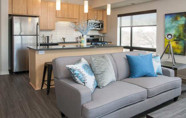 a living room with a couch in front of a kitchen