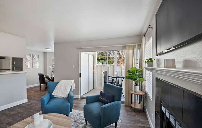 a living room with blue chairs and a fireplace