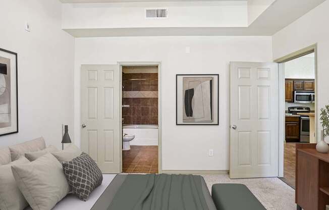 A living room with a couch, a painting, and a door leading to a bathroom.