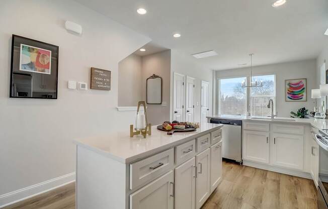 A kitchen with white cabinets and a large island.