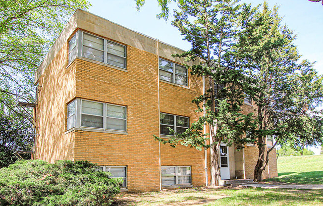 a brick building with trees in front of it