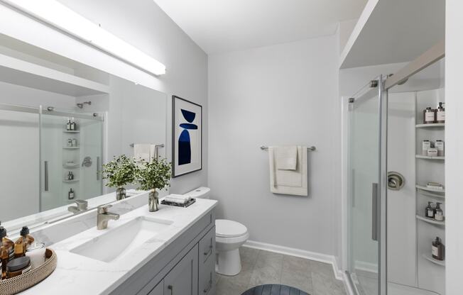 a white bathroom with a shower and a sink and a toilet