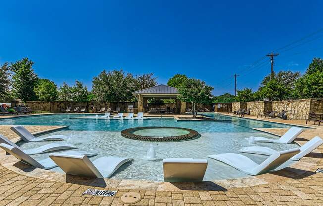 the pool is heated and has a gazebo and chairs around it at Discovery at Craig Ranch, Texas, 75070