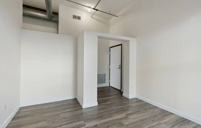 a bedroom with hardwood floors and white wallsat Gaar Scott Historic Lofts, Minnesota, 55401