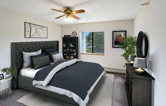 A bedroom with a large bed and a ceiling fan.