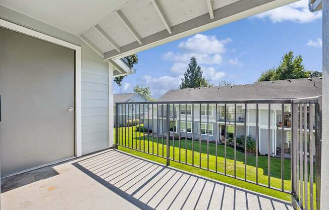 A patio with a metal railing and a sliding glass door.