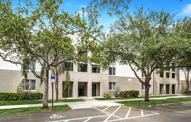 A parking lot in front of a building with trees.
