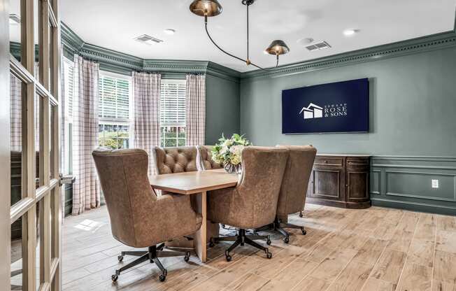 a conference room with a table and chairs and a tv