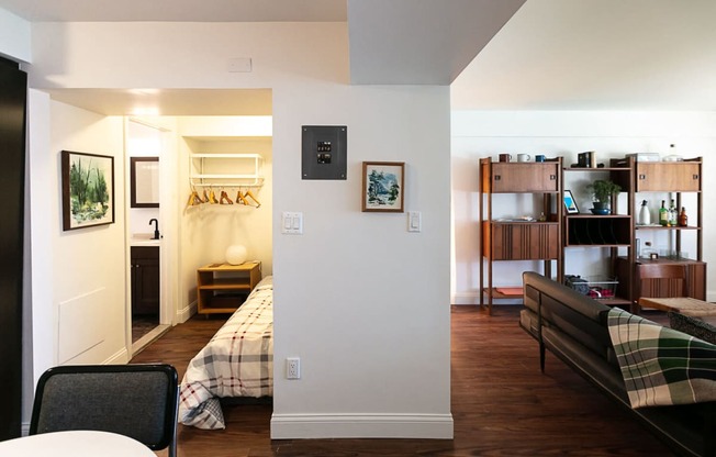 a bedroom with a bed and a living room with a desk