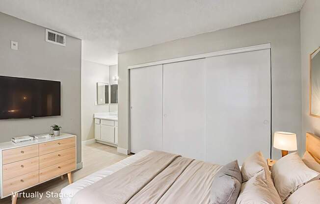 A bedroom with a bed, dresser, and mirror.