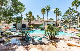 a swimming pool with palm trees and chairs around it