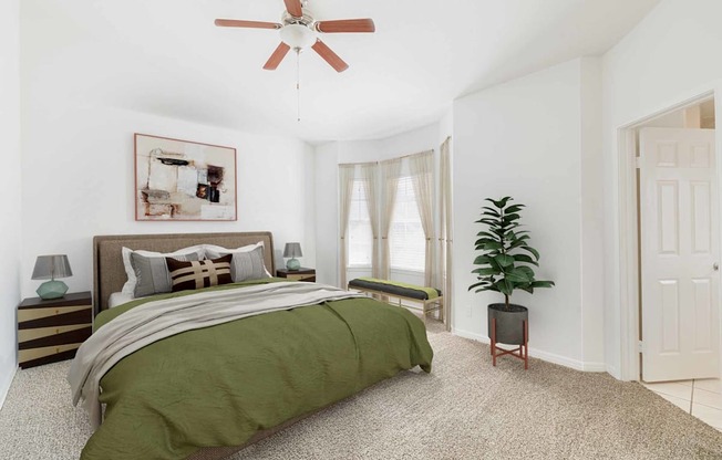 a bedroom with a bed and a ceiling fan