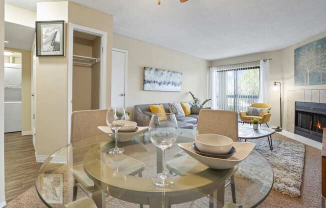 a living room with a glass table and a fireplace