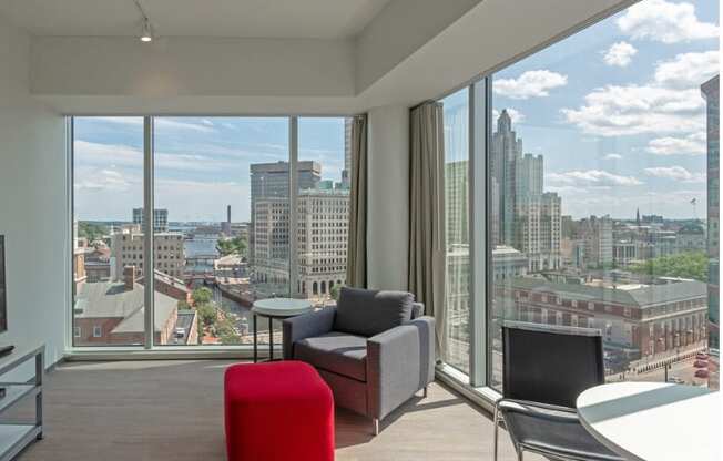 a living room with a view of the city and a table and chairs