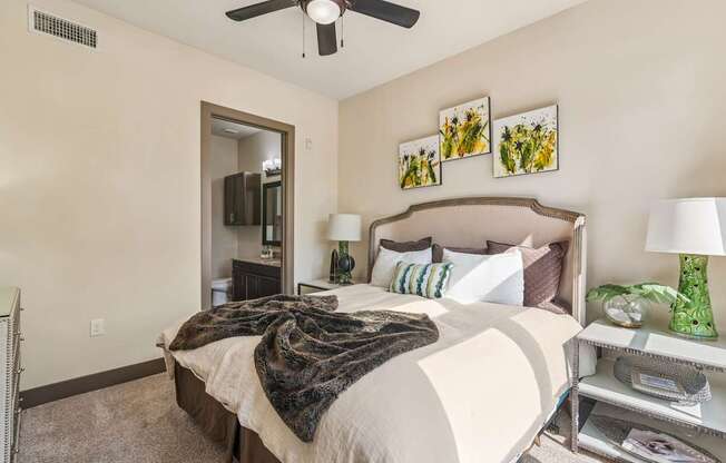A bedroom with a large bed and a ceiling fan.