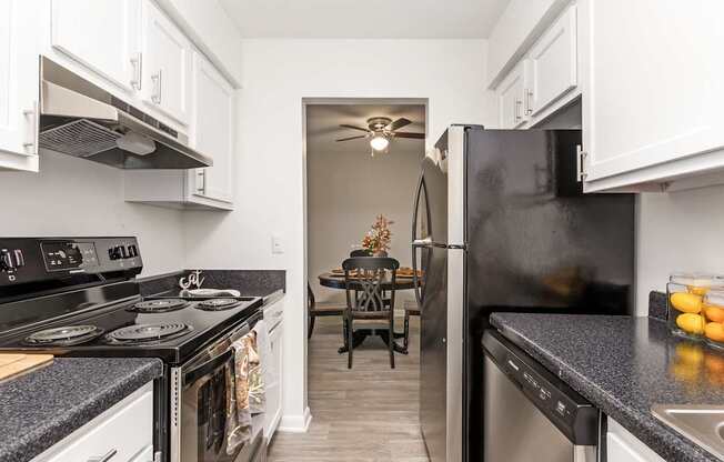 A kitchen with black appliances and white cabinets.