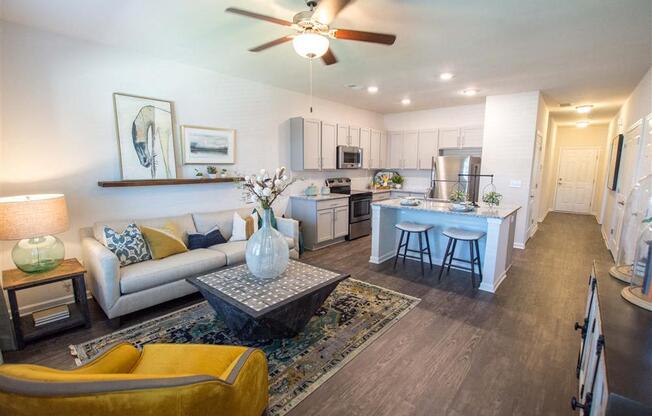 a living room and kitchen with a ceiling fan