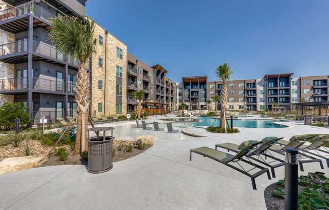 A sunny day at a resort with a pool and palm trees.
