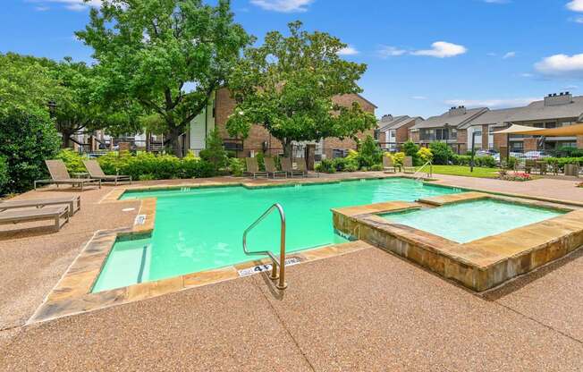 A swimming pool surrounded by a concrete floor and trees.