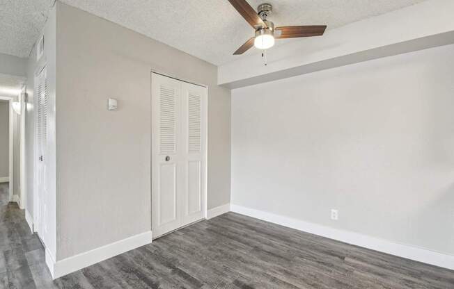 A room with a ceiling fan and a door.
