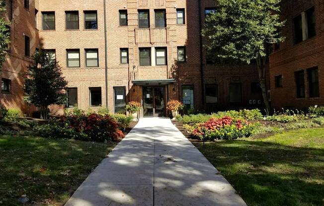 a large brick building with a sidewalk in front of it