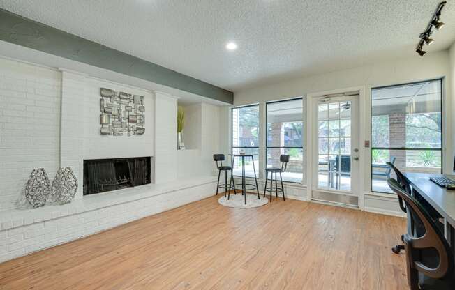 a living room with a fireplace and a wood floor    and a balcony