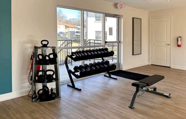 Fitness center with free weights, weight bench, and kettle bells  at Huntsville Landing Apartments, Huntsville, AL, 35806