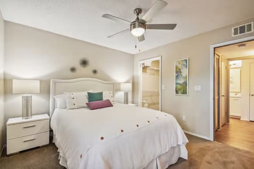 a bedroom with a bed and a ceiling fan