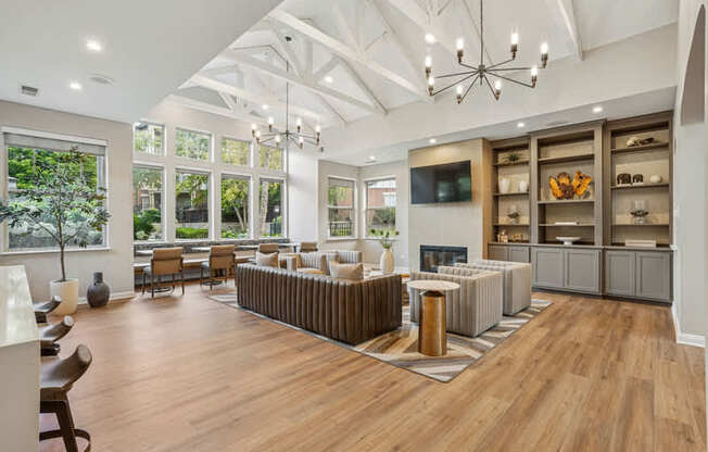 A spacious living room with a fireplace and a large chandelier.