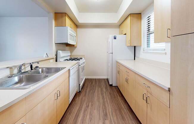 A kitchen with wooden cabinets and a white appliances at Foxwood and The Hermitage, Michigan