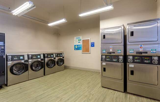 a laundry room with a row of washing machines and refrigerators