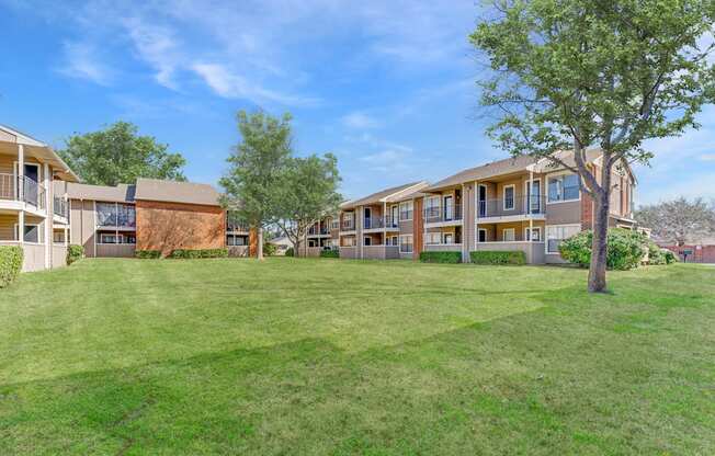 A grassy area in front of apartment buildings.