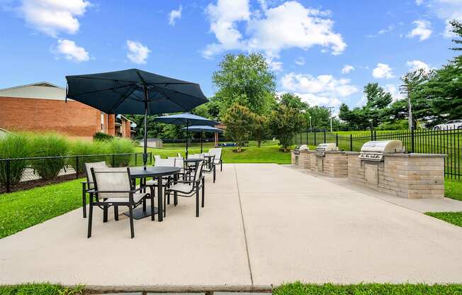 A patio with a table and chairs under an umbrella.