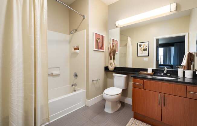 a bathroom with a shower toilet and sink and a mirror