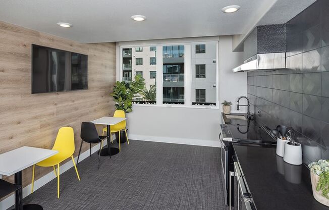 a room with a table and chairs and a television on the wall